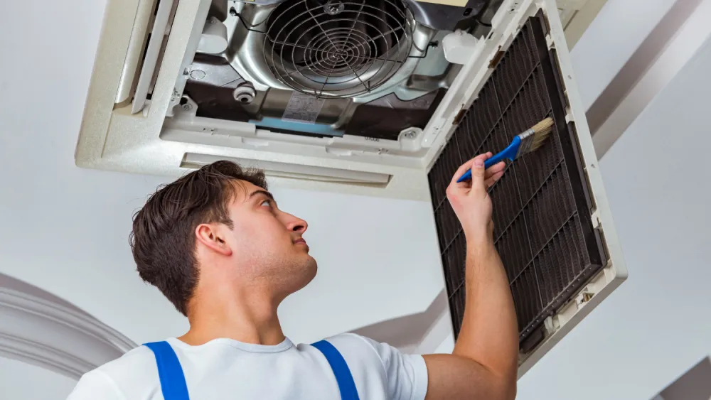 "Professional HVAC technician performing maintenance on an air conditioning unit, ideal for HVAC services and repair topics."