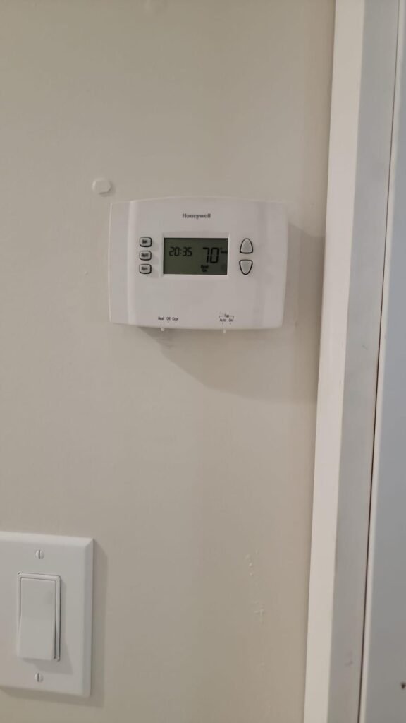 Modern thermostat on a wall in a Houston home showcasing advanced HVAC control