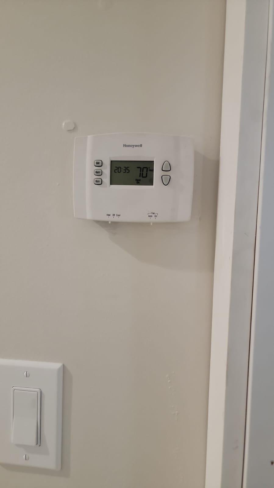 Modern thermostat on a wall in a Houston home, showcasing advanced HVAC control.
